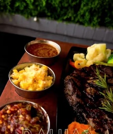 Grilled steak served with sides at Bahía